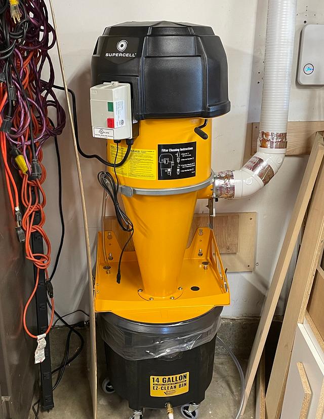 Oneida Air Systems Supercell connected to a woodworking machine, actively collecting sawdust during operation